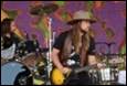 A person playing guitar on stage

Description automatically generated with medium confidence