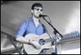 A person playing guitar and singing into a microphone

Description automatically generated with low confidence
