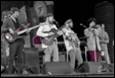 A group of men playing instruments on a stage

Description automatically generated with medium confidence