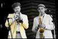 A couple of men playing instruments

Description automatically generated with low confidence