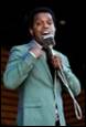 A person in a suit holding a microphone

Description automatically generated with medium confidence