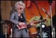 A person playing a guitar on stage

Description automatically generated with medium confidence