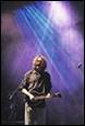 A person playing a guitar on stage

Description automatically generated