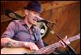 A person playing guitar and singing

Description automatically generated