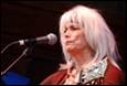 A person with white hair and a guitar

Description automatically generated
