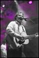A person playing guitar and singing into microphone

Description automatically generated