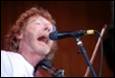 A person singing into a microphone

Description automatically generated