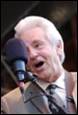 A person speaking into a microphone

Description automatically generated