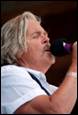 A person singing into a microphone

Description automatically generated