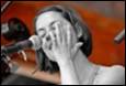 A person singing into a microphone

Description automatically generated