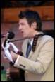 A person in a suit holding a guitar

Description automatically generated