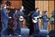 A group of people playing instruments on a stage

Description automatically generated