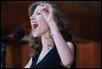 A person singing into a microphone

Description automatically generated