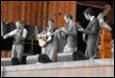A group of men playing instruments

Description automatically generated