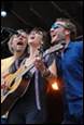 A group of people singing and playing instruments

Description automatically generated