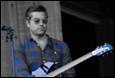 A person holding a guitar

Description automatically generated