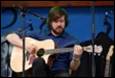 A person playing a guitar

Description automatically generated