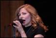 A person singing into a microphone

Description automatically generated