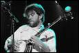A person playing a banjo on stage

Description automatically generated
