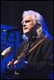 A person with long hair playing guitar

Description automatically generated