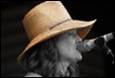 A person wearing a hat and smoking a microphone

Description automatically generated