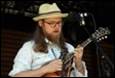 A person with a hat playing a guitar

Description automatically generated