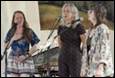 A group of women singing into microphones

Description automatically generated