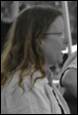 A person with long hair wearing glasses

Description automatically generated