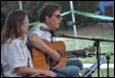 A person and person playing guitar

Description automatically generated