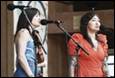 A group of women singing into microphones

Description automatically generated