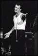 A person in a white tank top and black pants holding a microphone

Description automatically generated with low confidence