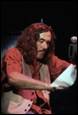A person with long hair holding a piece of paper

Description automatically generated with low confidence