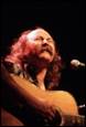 A person with long hair playing guitar

Description automatically generated