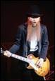 A person with long beard playing guitar

Description automatically generated