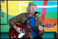 A person playing guitar and singing

Description automatically generated with medium confidence