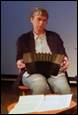 A person sitting in a chair holding an accordion

Description automatically generated with medium confidence