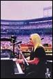 A person playing a piano in a stadium

Description automatically generated with low confidence