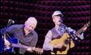 Two men playing instruments on a stage

Description automatically generated
