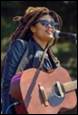 A person with dreadlocks holding a guitar

Description automatically generated