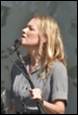 A person with blonde hair holding a microphone

Description automatically generated