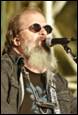 A person with a beard singing into a microphone

Description automatically generated