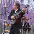 A person playing a guitar on a stage

Description automatically generated
