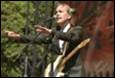 A person with a guitar and microphone

Description automatically generated
