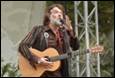 A person with a beard playing a guitar

Description automatically generated
