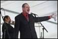 A person in a suit singing into a microphone

Description automatically generated with low confidence