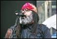 A person with a beard and a red bandana singing into a microphone

Description automatically generated with low confidence