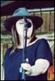 A person wearing a hat and holding a microphone

Description automatically generated with medium confidence