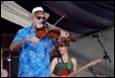 A person playing a violin and a person playing instruments

Description automatically generated with low confidence