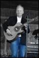 A person holding a guitar

Description automatically generated