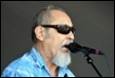 A person with sunglasses and a beard singing into a microphone

Description automatically generated with low confidence